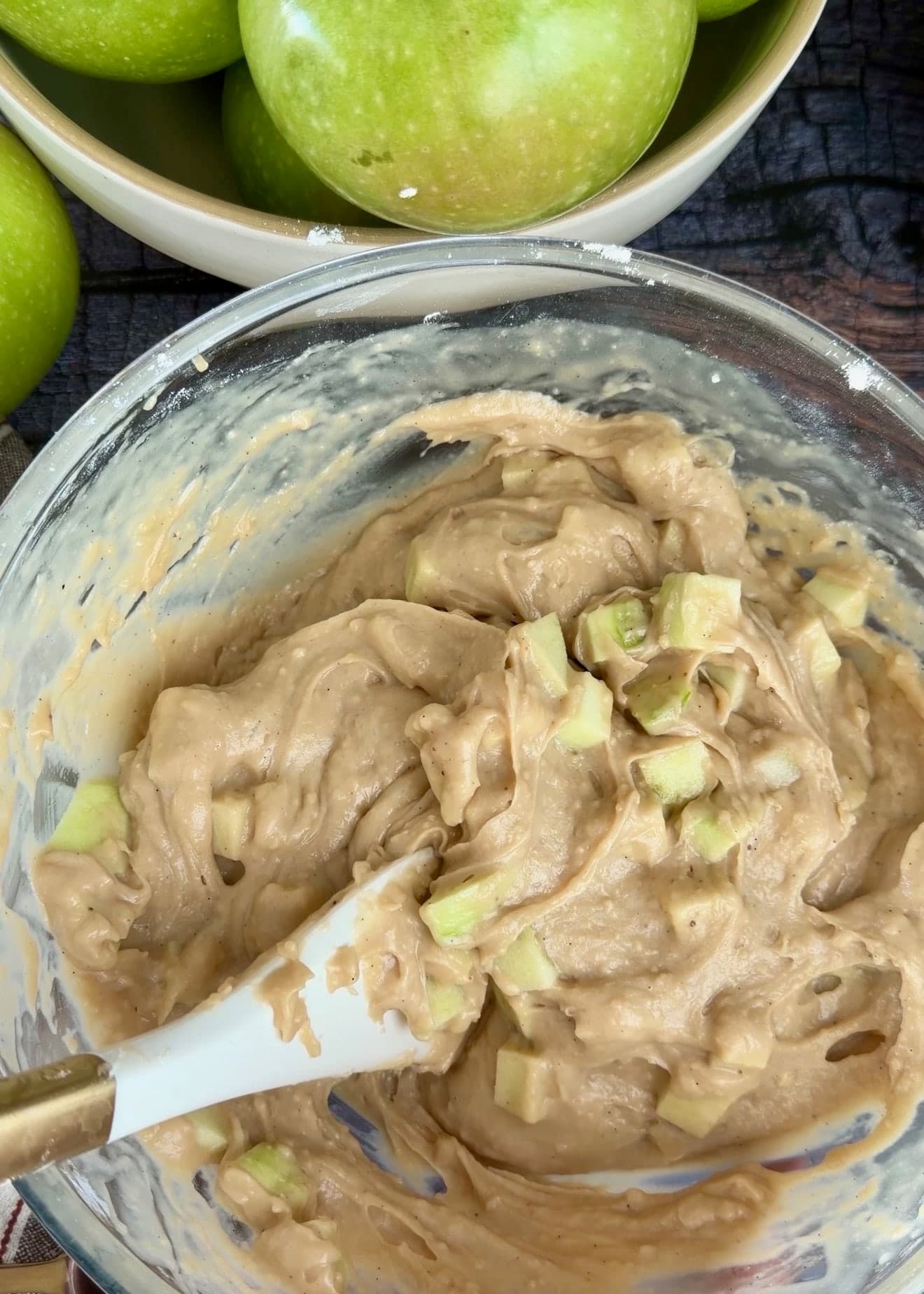 Apple pieces folded through thick batter around a spatula