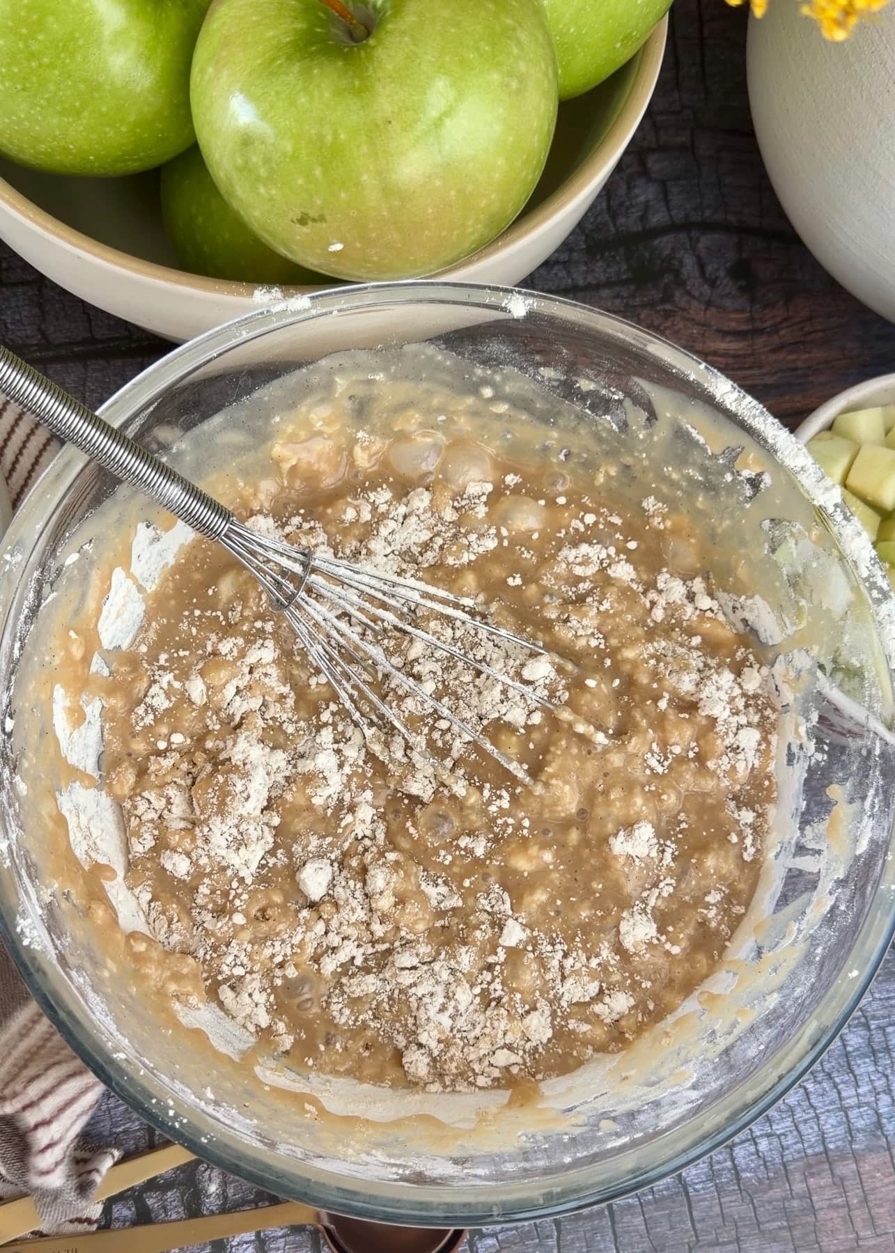 Partially mixed cake batter with visible pockets of dry flour