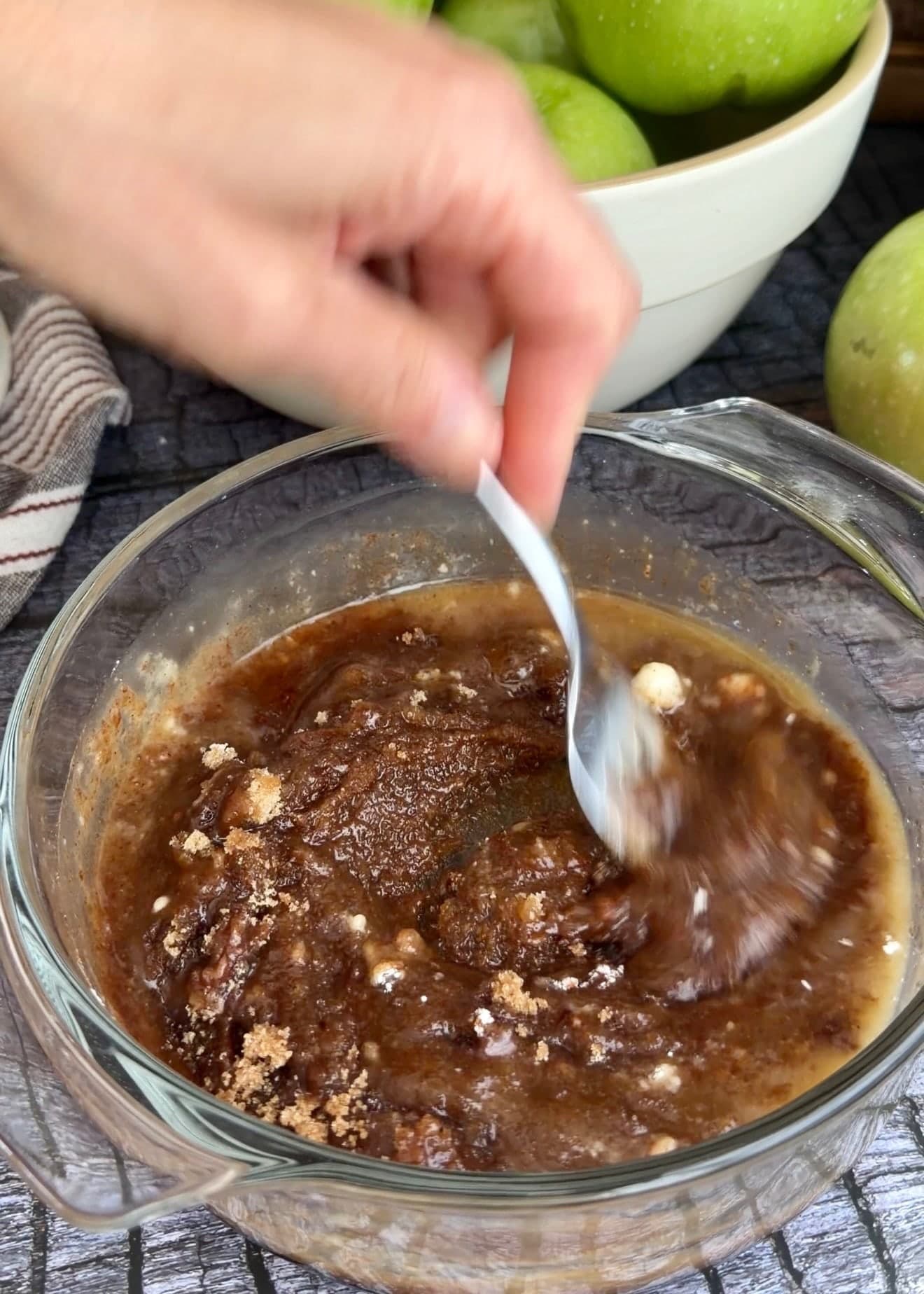 A spoon stirring butter into the brown cinnamon mixture