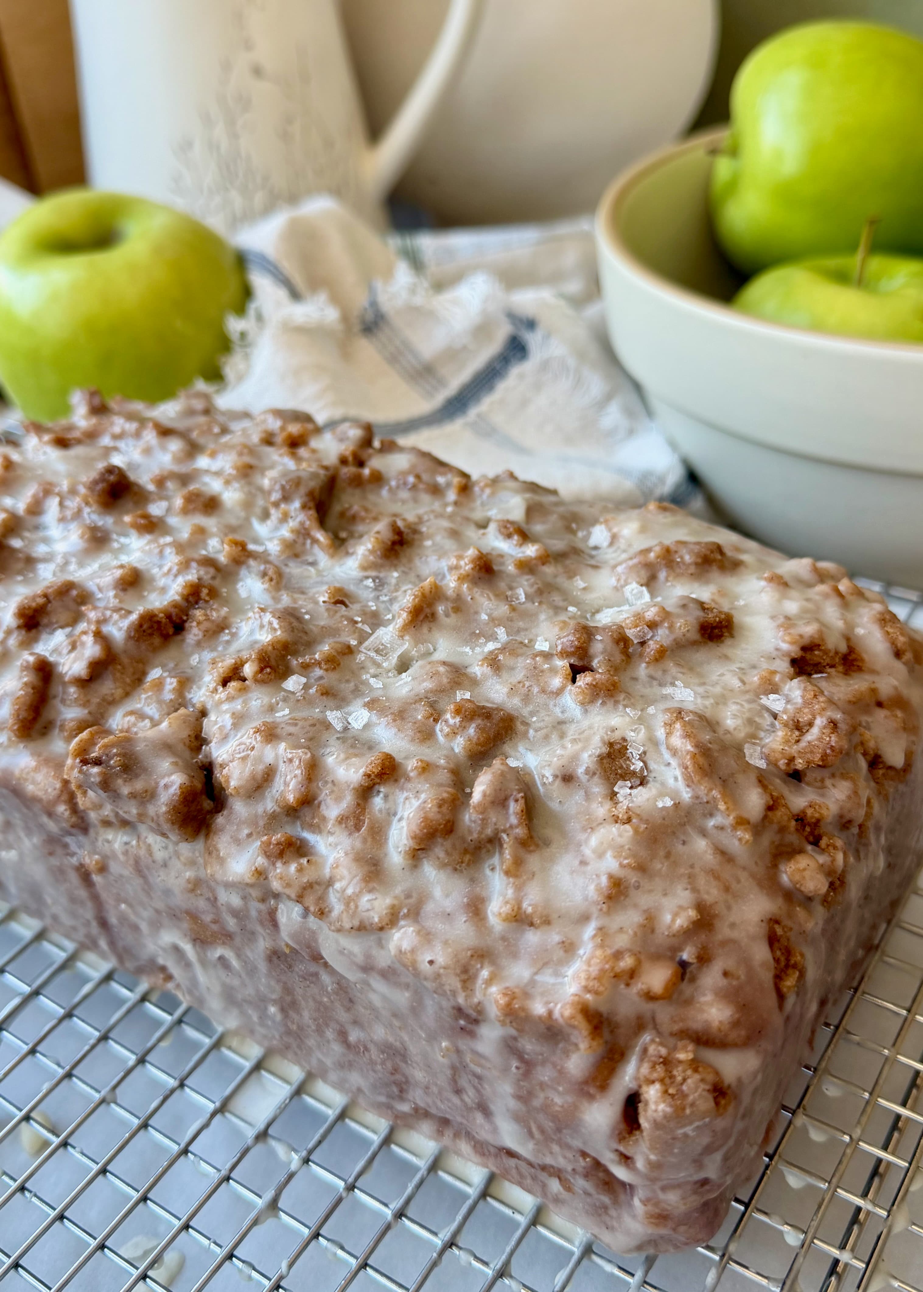 Finished glazed Apple Fritter Old-Fashioned Donut Loaf with green apples in the background
