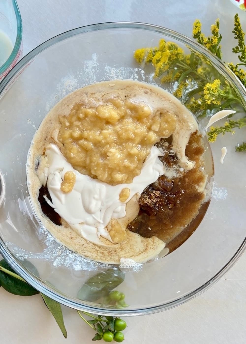 Very ripe mashed bananas with the wet ingredients for banana cake