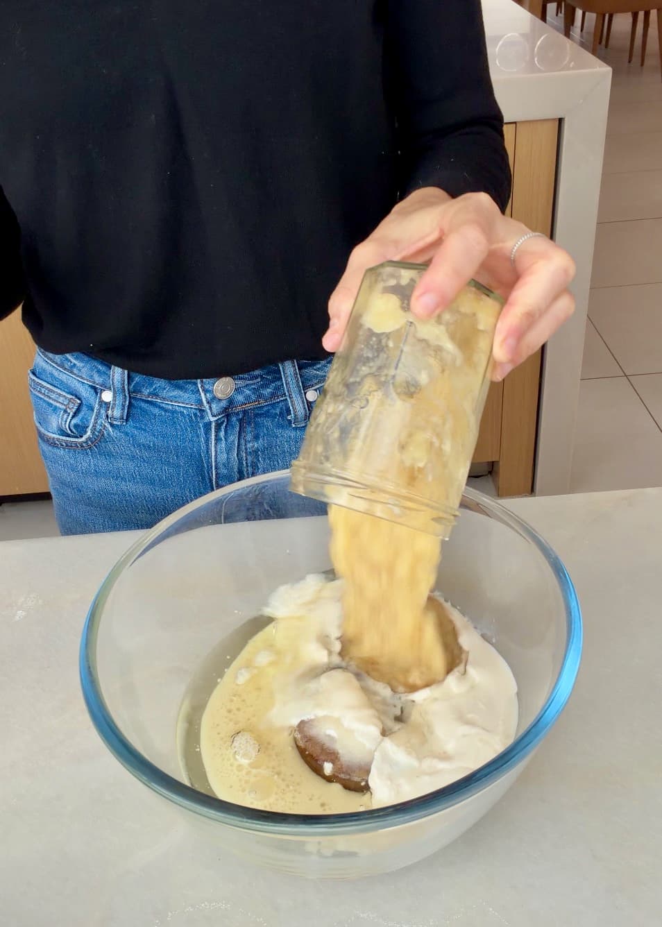 Mashed banana falling from a container into the cake mixing bowl