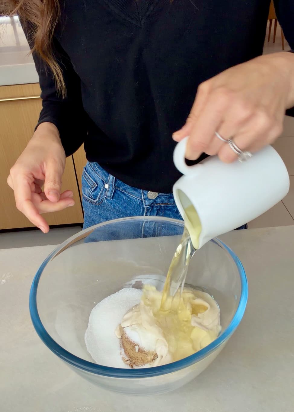 Oil pouring into the bowl of wet cake ingredients and sugars