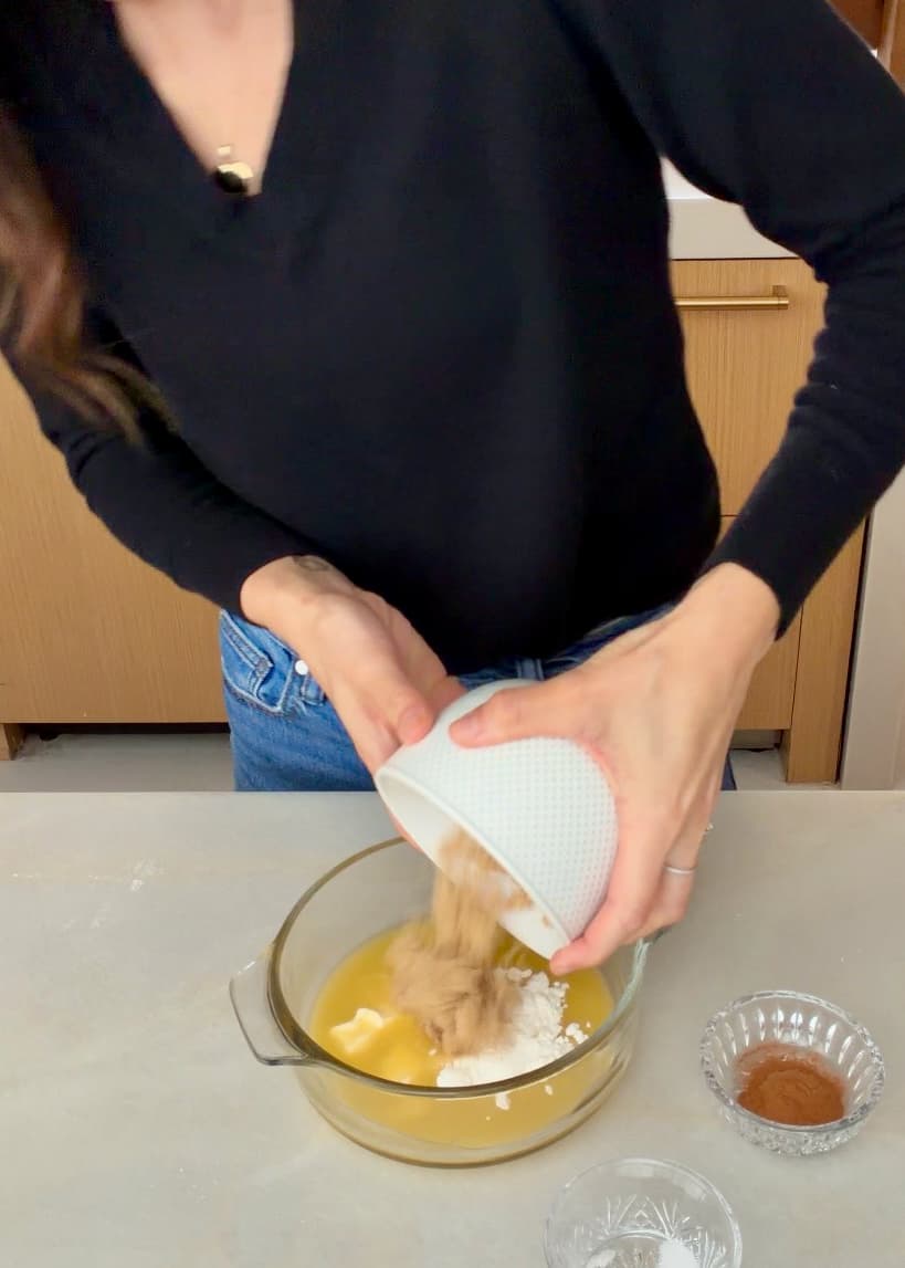 Brown sugar being added to melted butter for the cinnamon filling