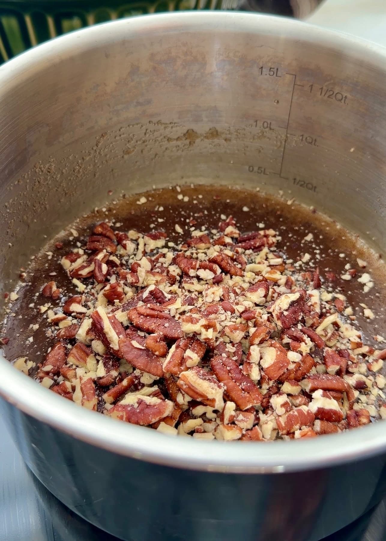 Chopped pecans sitting on the brown sugar topping in the saucepan