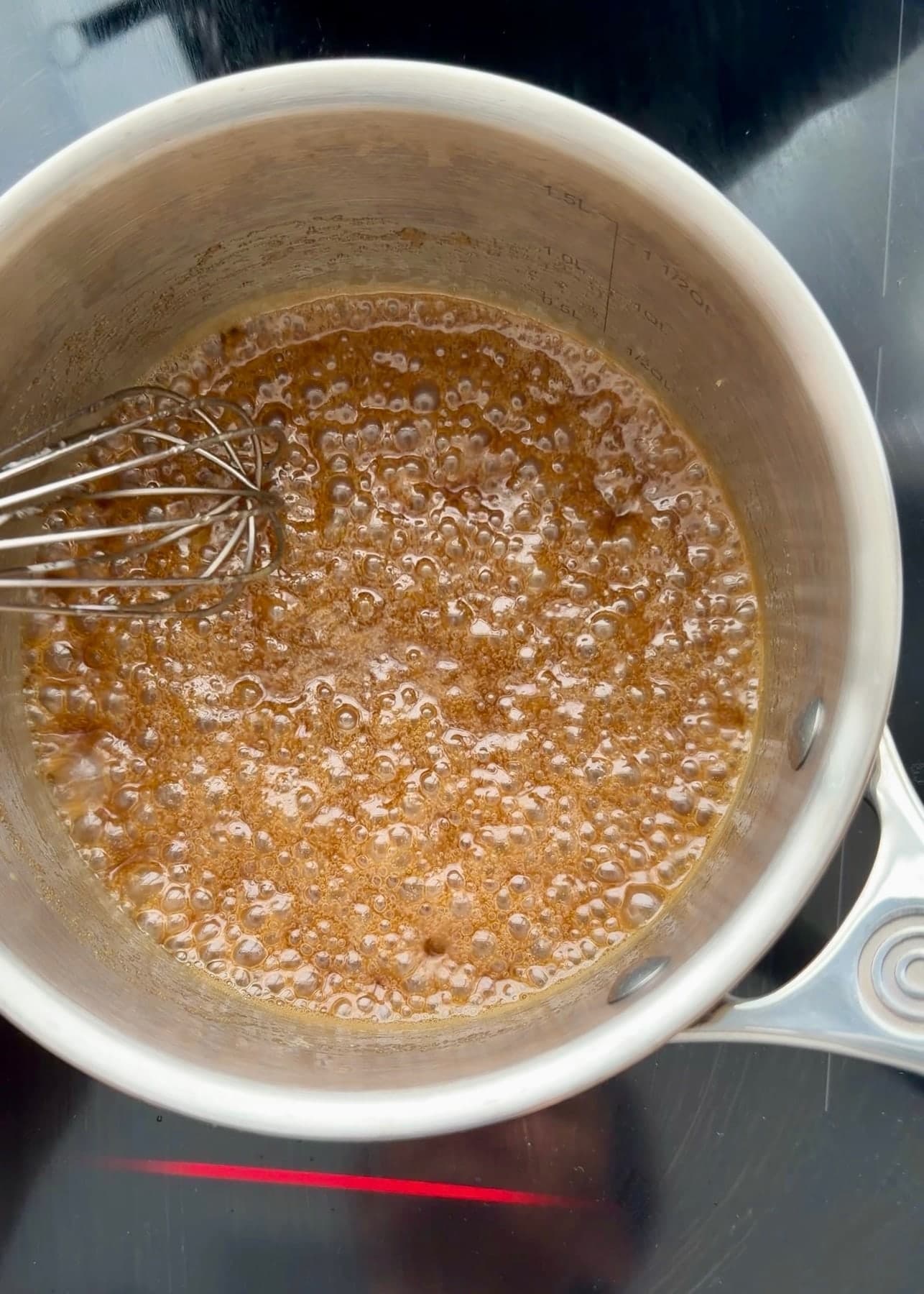 The topping bubbling across the surface of the saucepan after the cream is added