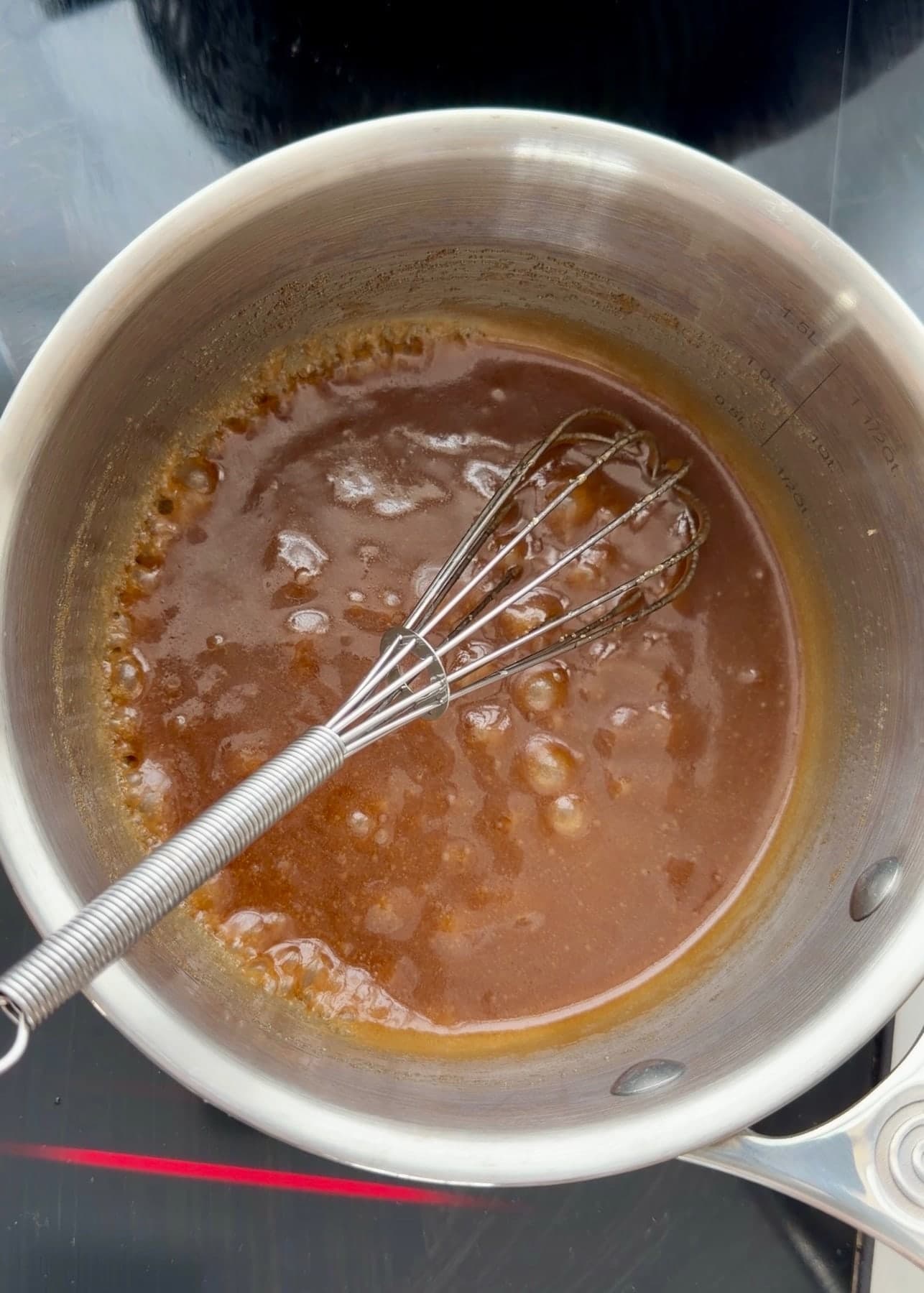 Melted butter and brown sugar bubbling around a whisk in the saucepan