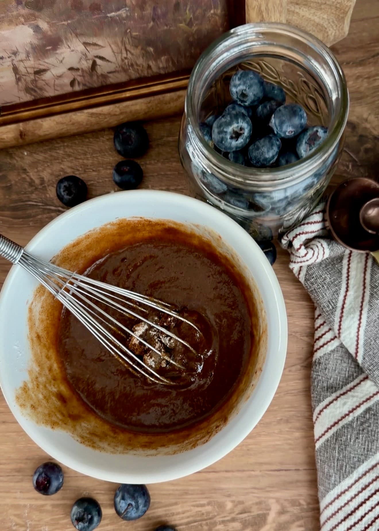 Smooth brown cinnamon filling in a bowl with a whisk