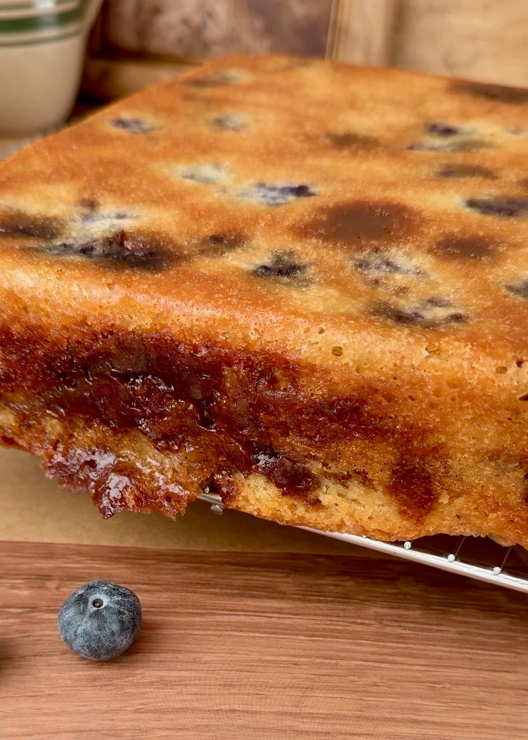 The flat underside of the blueberry cake after the parchment has been removed