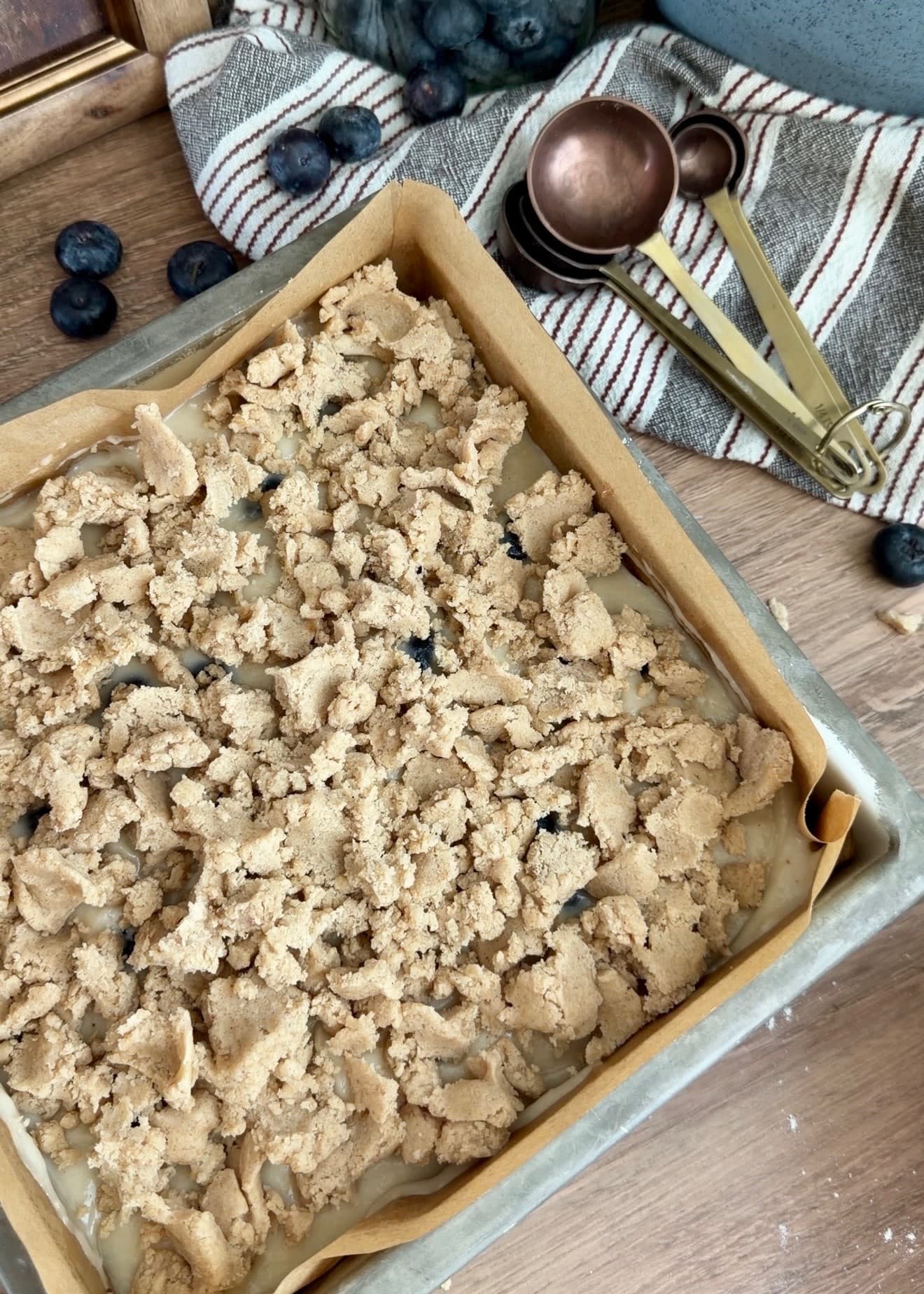 Unbaked blueberry coffee cake covered with large crumble clusters