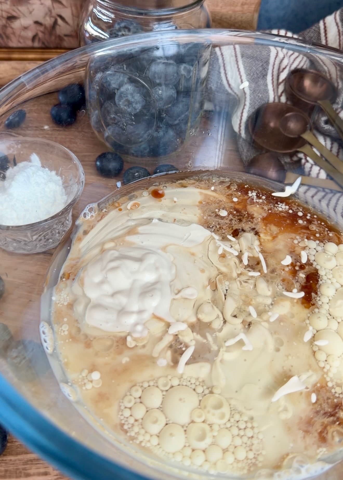 Yogurt and other wet cake ingredients in a glass mixing bowl