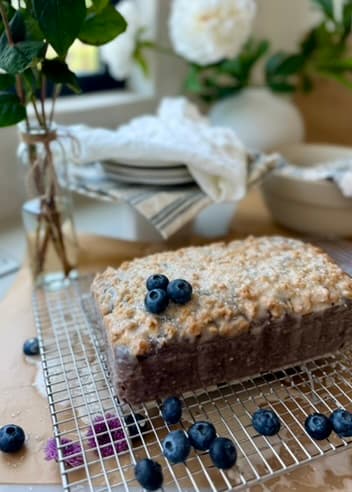Finished Blueberry Old-Fashioned Donut Loaf glazed and resting on a cooling rack