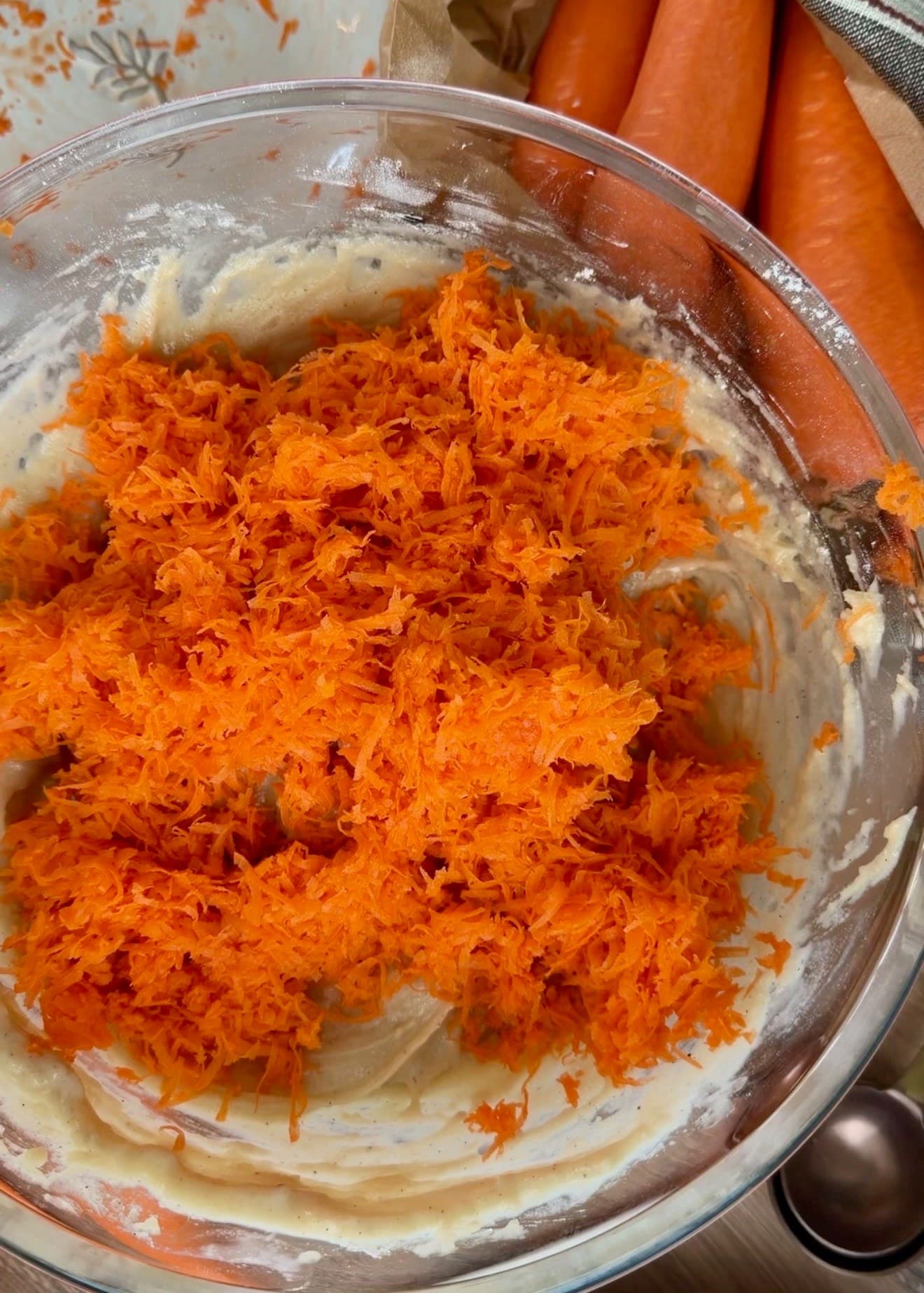 Finely grated carrots piled on thick pale batter