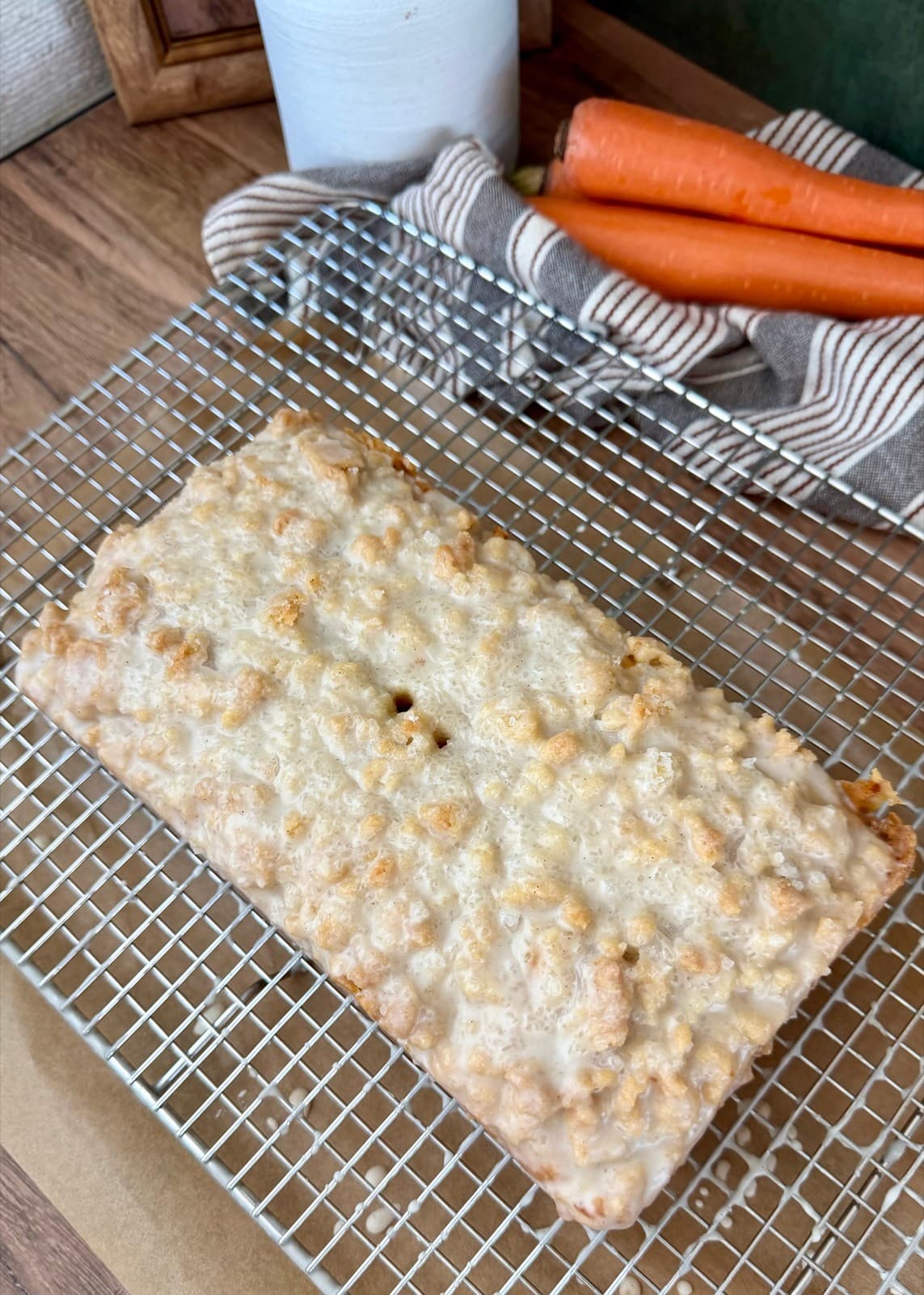 The whole glazed carrot streusel loaf resting directly on a wire rack
