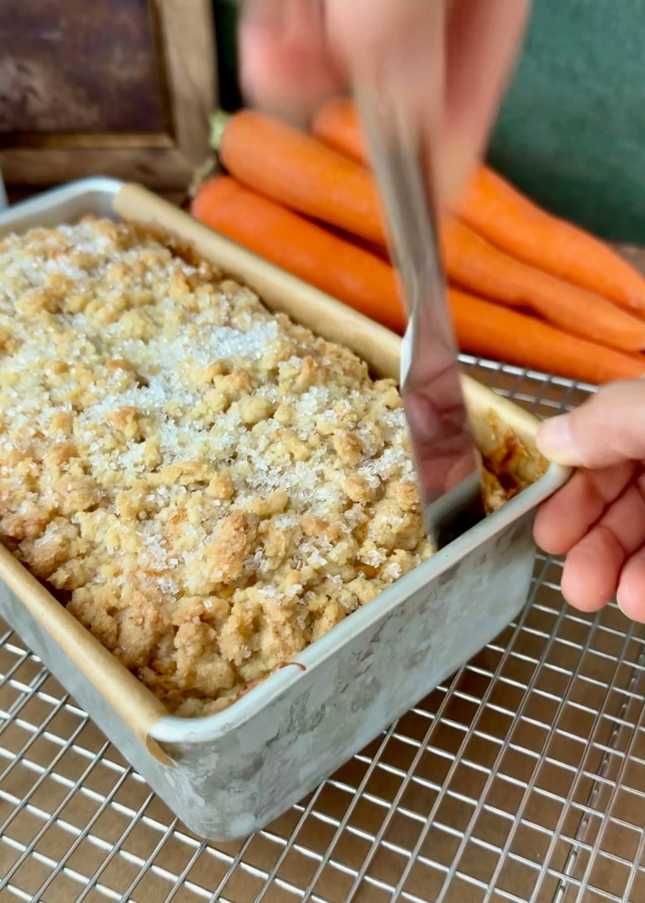 An offset spatula loosening the baked loaf from the end of its pan