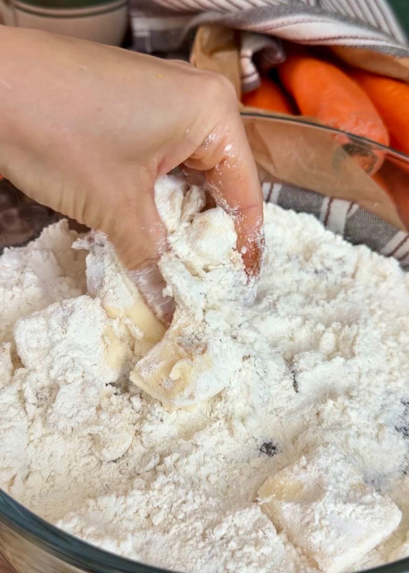 Fingertips working butter into the flour mixture