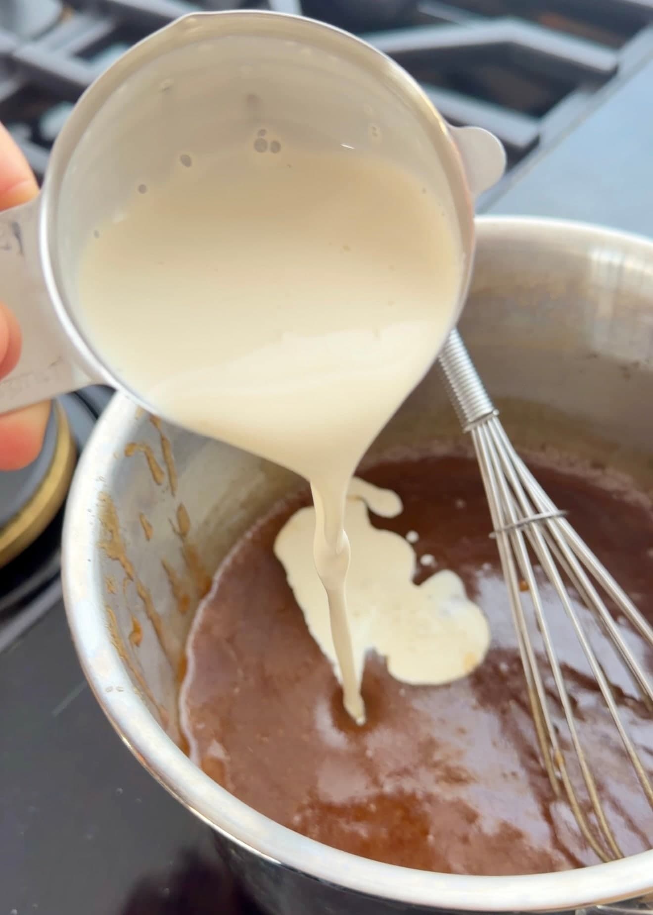 Cream being poured into the warm cinnamon and brown sugar mixture