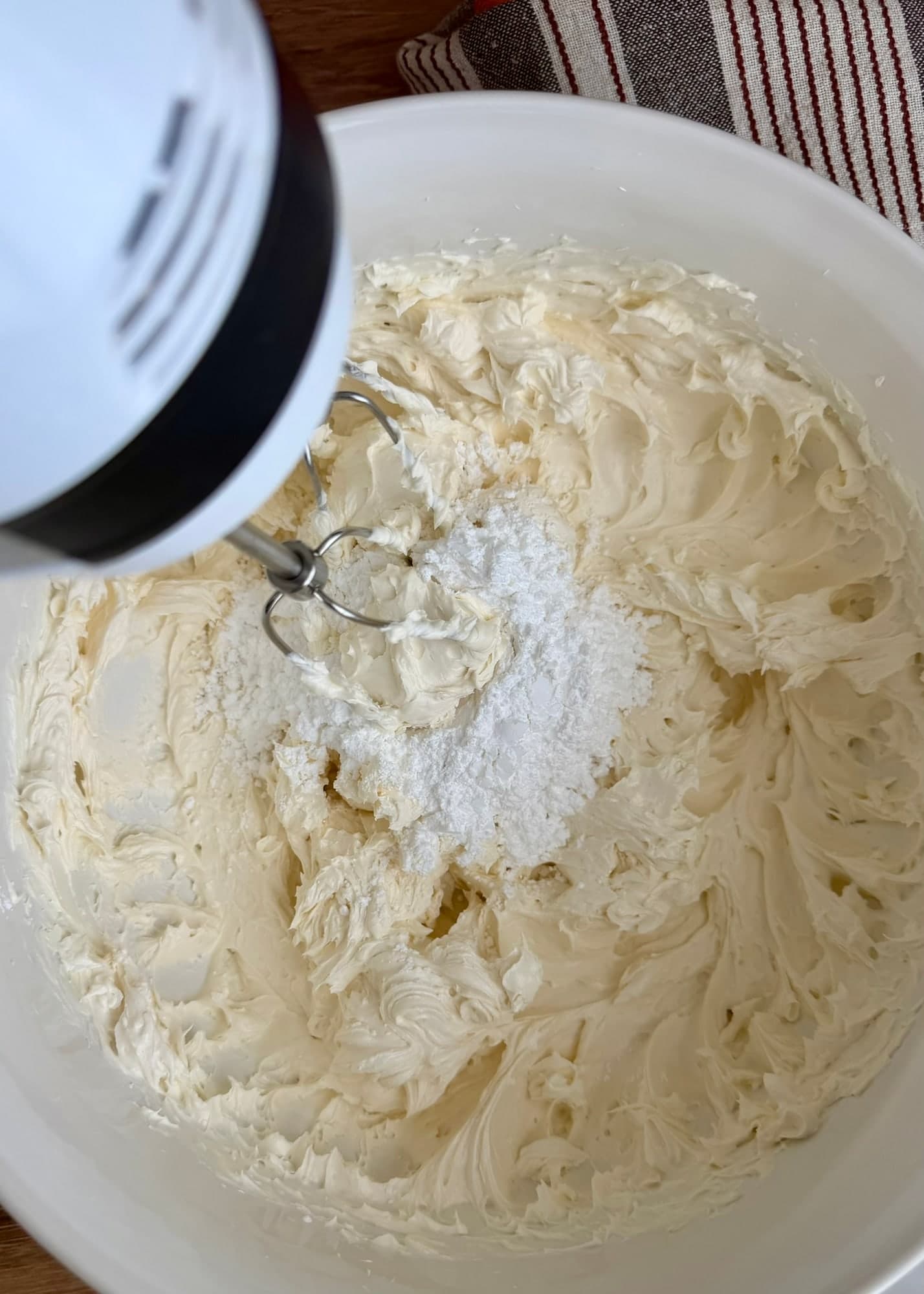 Powdered sugar being beaten into the butter before cream cheese is added