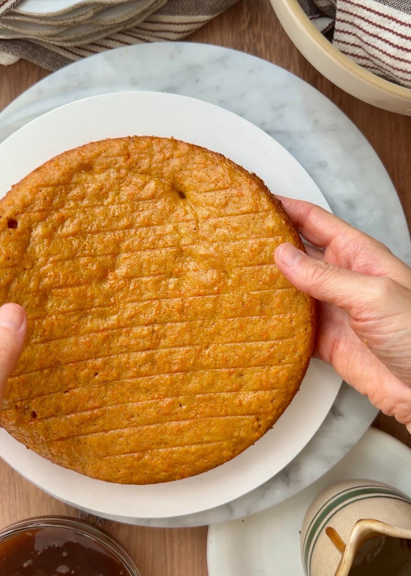 A cooled carrot cake layer placed on a cake board