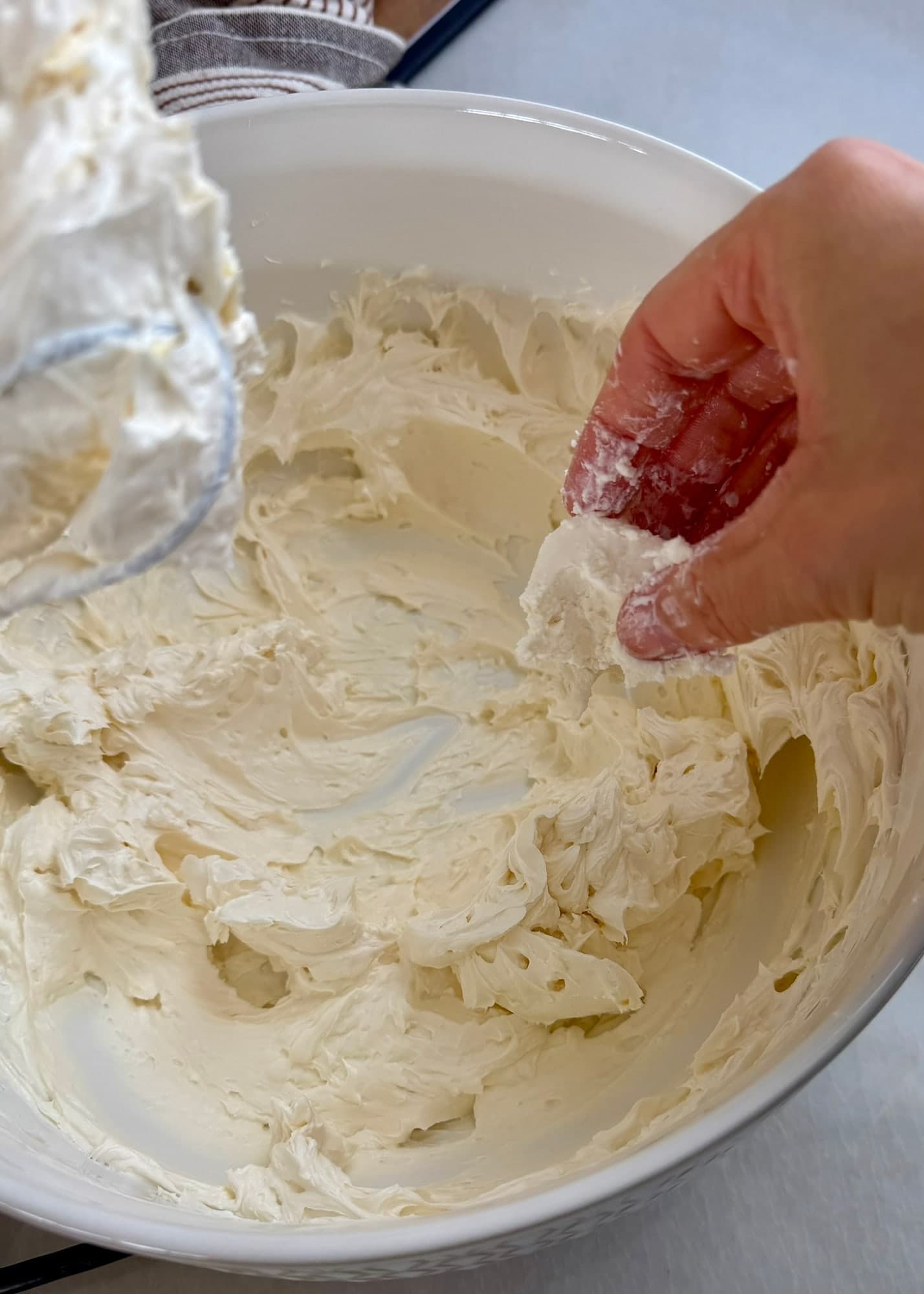 A piece of softened brick cream cheese added to the butter and powdered sugar base