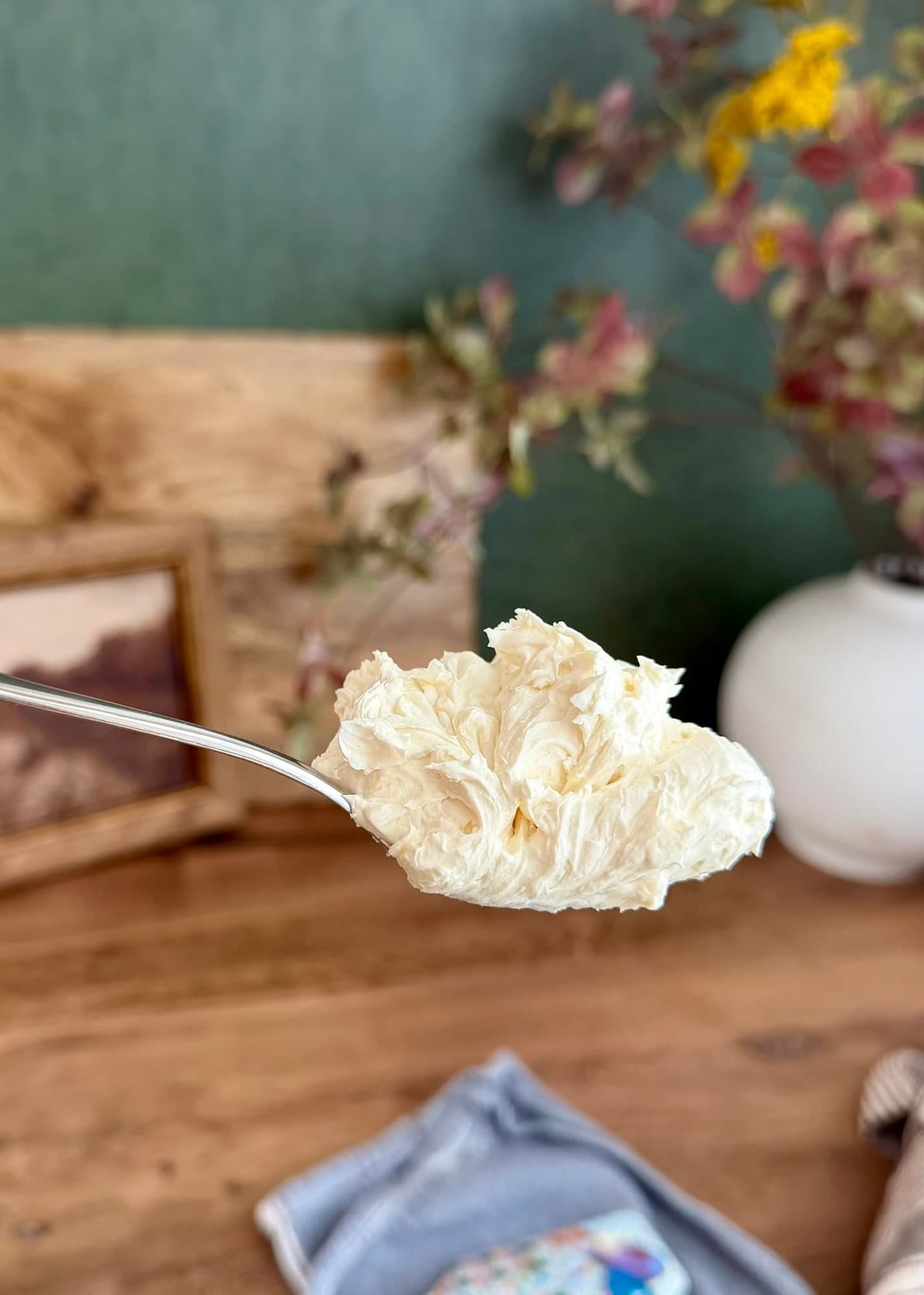 Finished cream cheese frosting holding its shape on a spoon