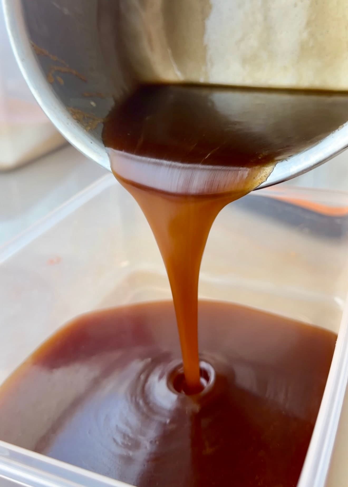 Warm cinnamon roll filling poured into a container to cool