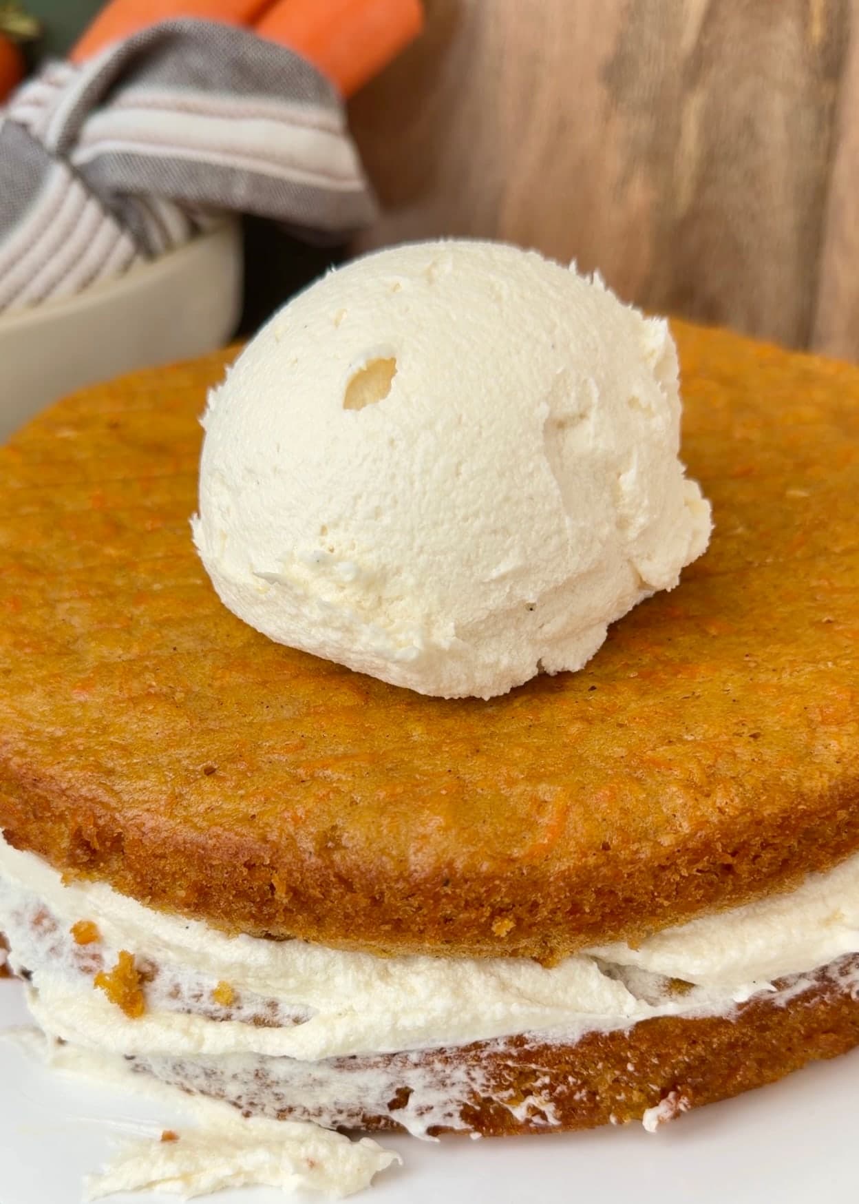 Frosting added to the next carrot cake layer after stacking