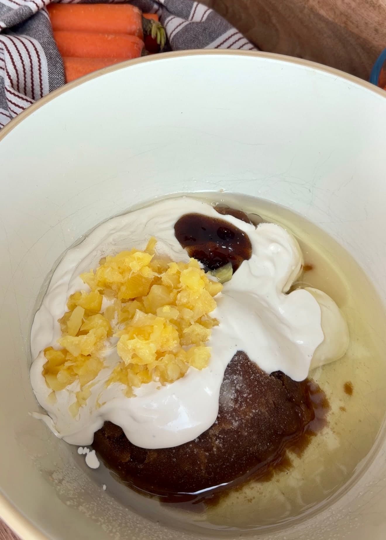 Sugars, oil, yogurt, pineapple, and vanilla ready to be whisked for carrot cake