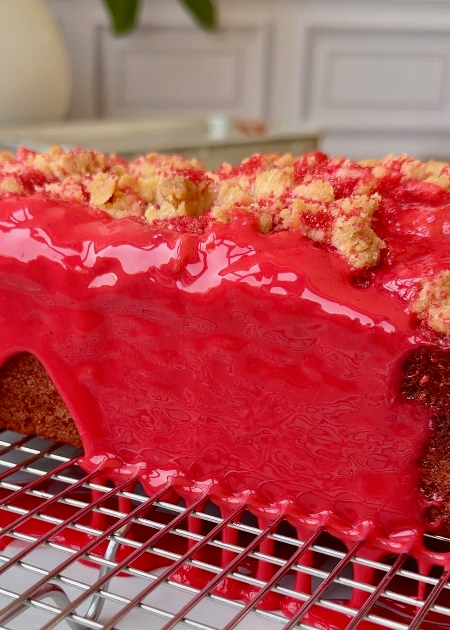 Vanilla glaze covering the cherry loaf streusel