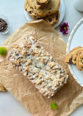 Finished chocolate chip donut loaf on parchment beside cookies