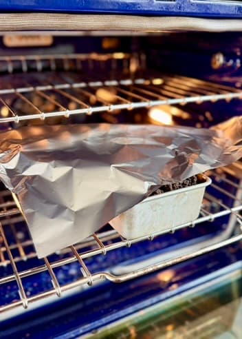 Loaf pan covered with a loose foil tent in the oven