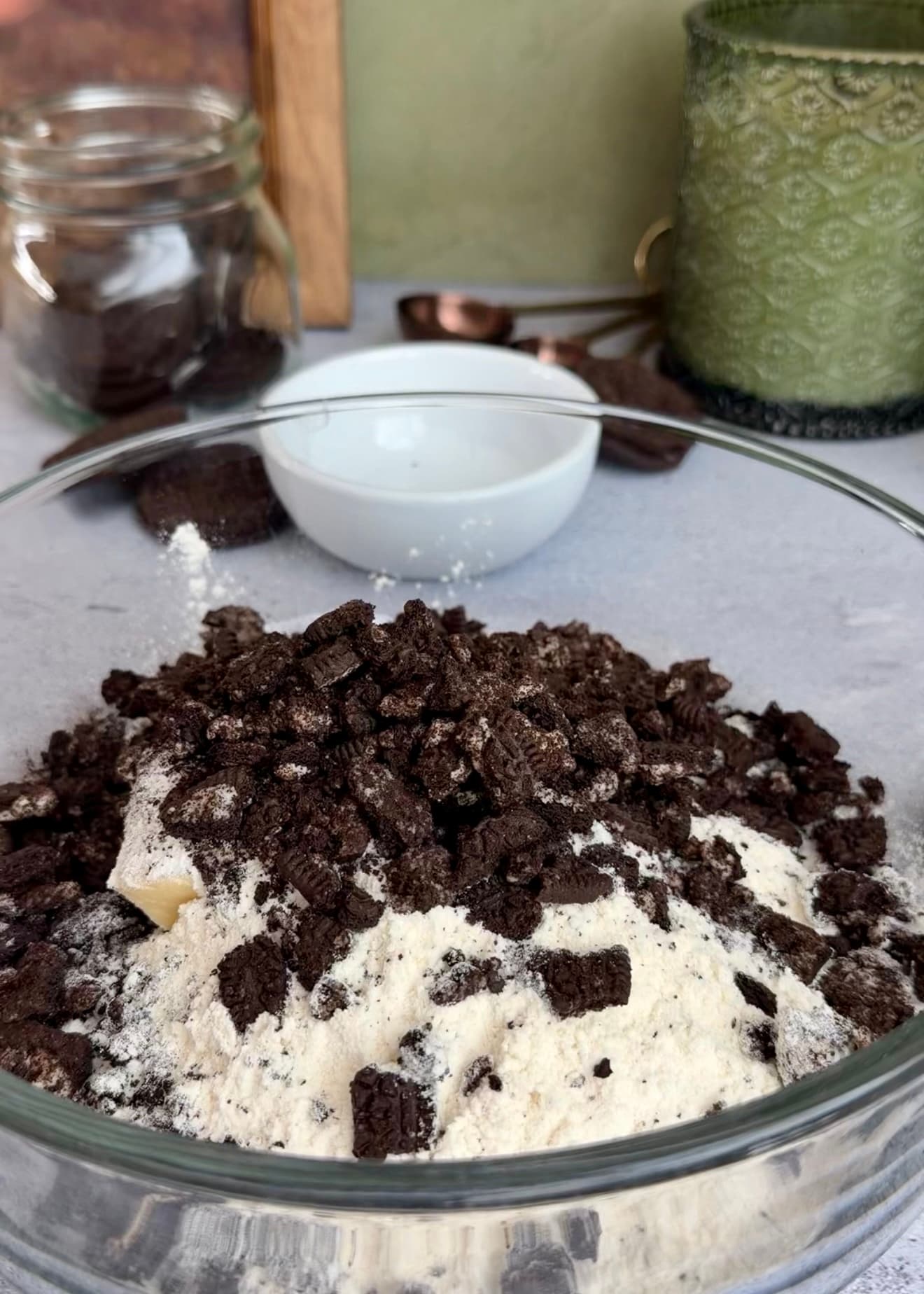 Crushed Oreos over flour and butter in a glass bowl