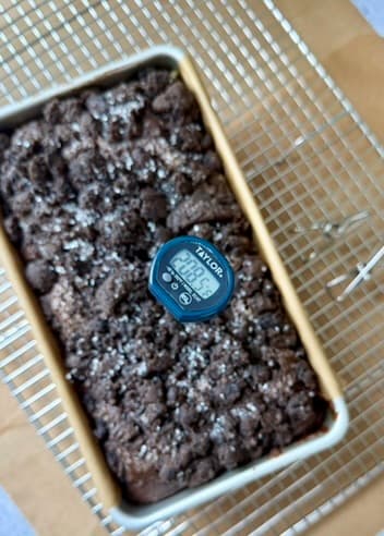 Thermometer showing approximately 208 degrees Fahrenheit in the loaf
