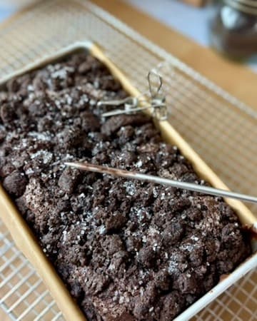 A metal tester held over the baked Oreo streusel loaf