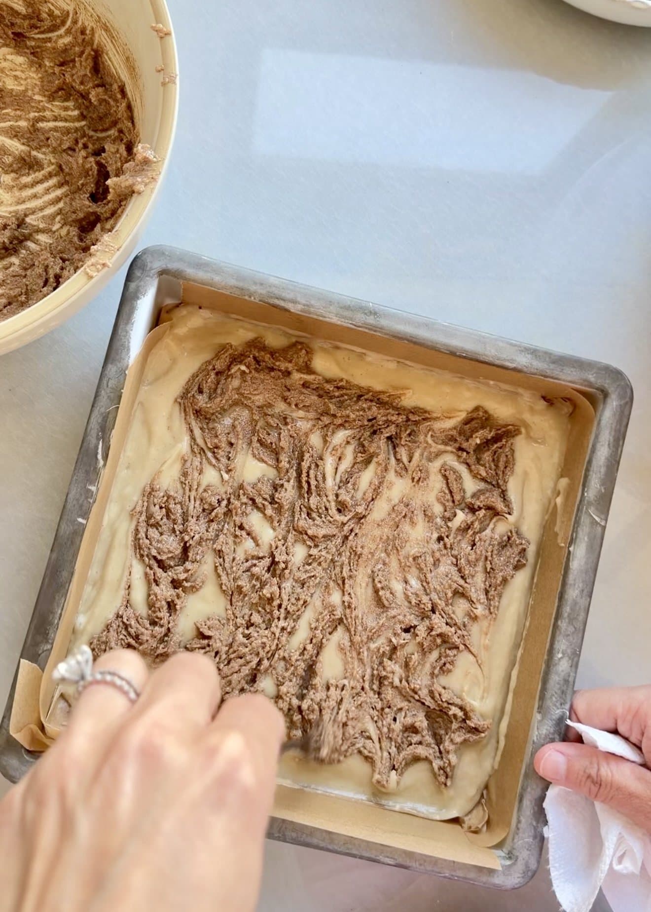 Cinnamon paste being lightly swirled through coffee cake batter