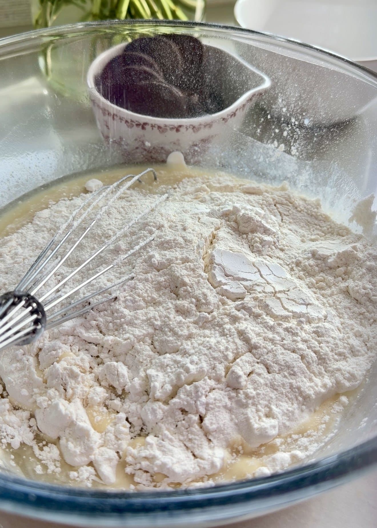 Dry ingredients over wet ingredients in a glass bowl