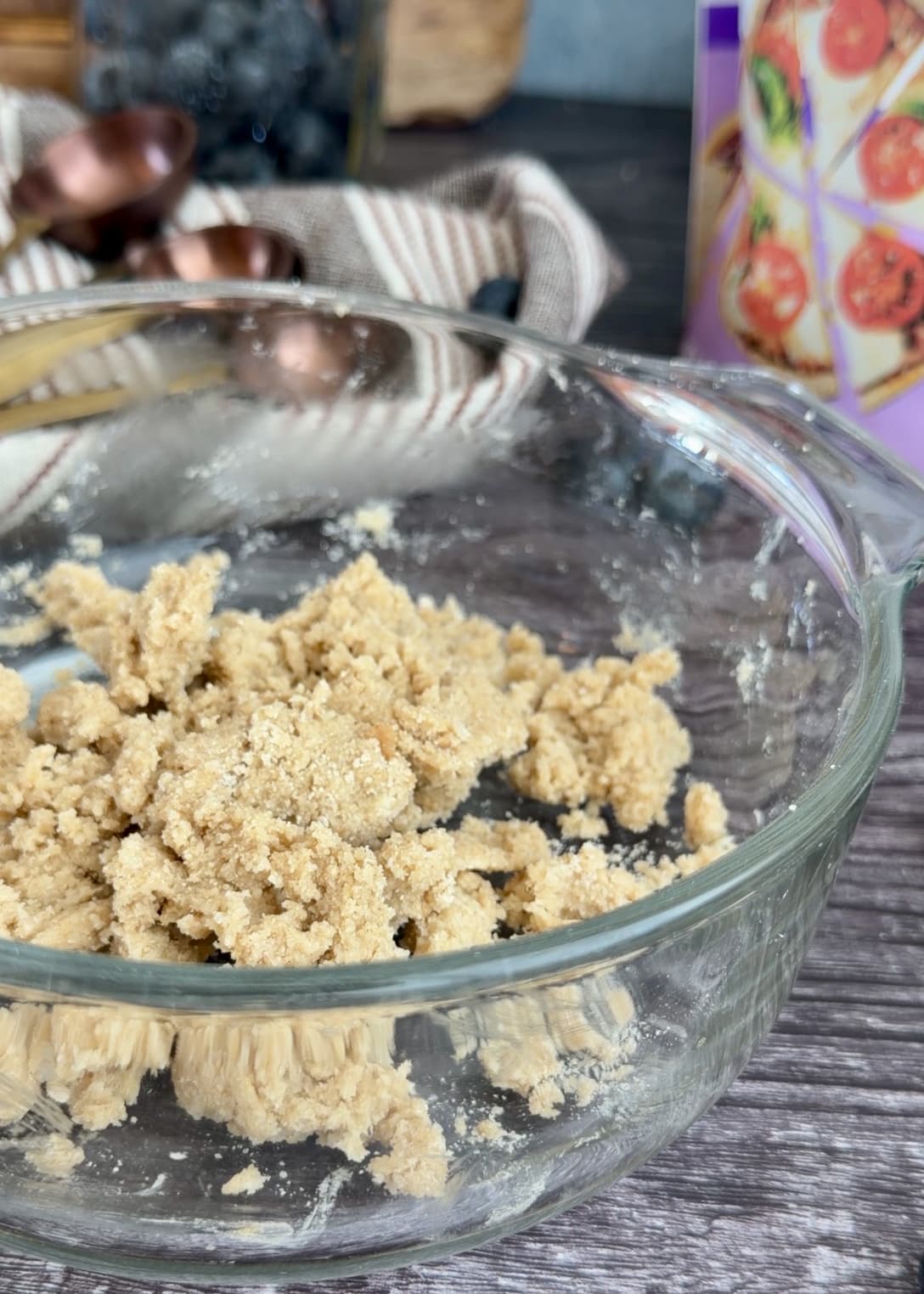 Pale crumble in a glass bowl with small crumbs and larger clusters
