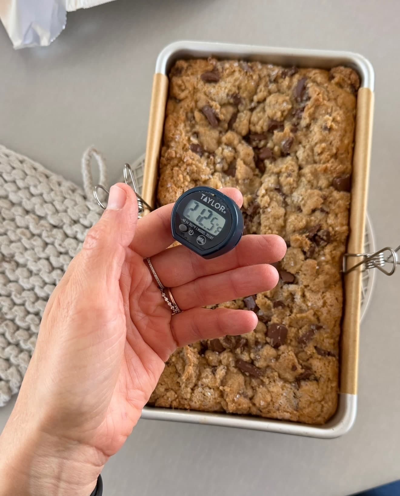 A thermometer reading 212.5°F held over the baked streusel loaf in its pan