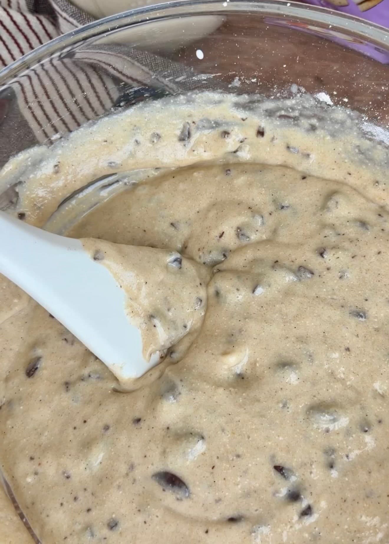 Thick chocolate-studded batter resting around a white spatula