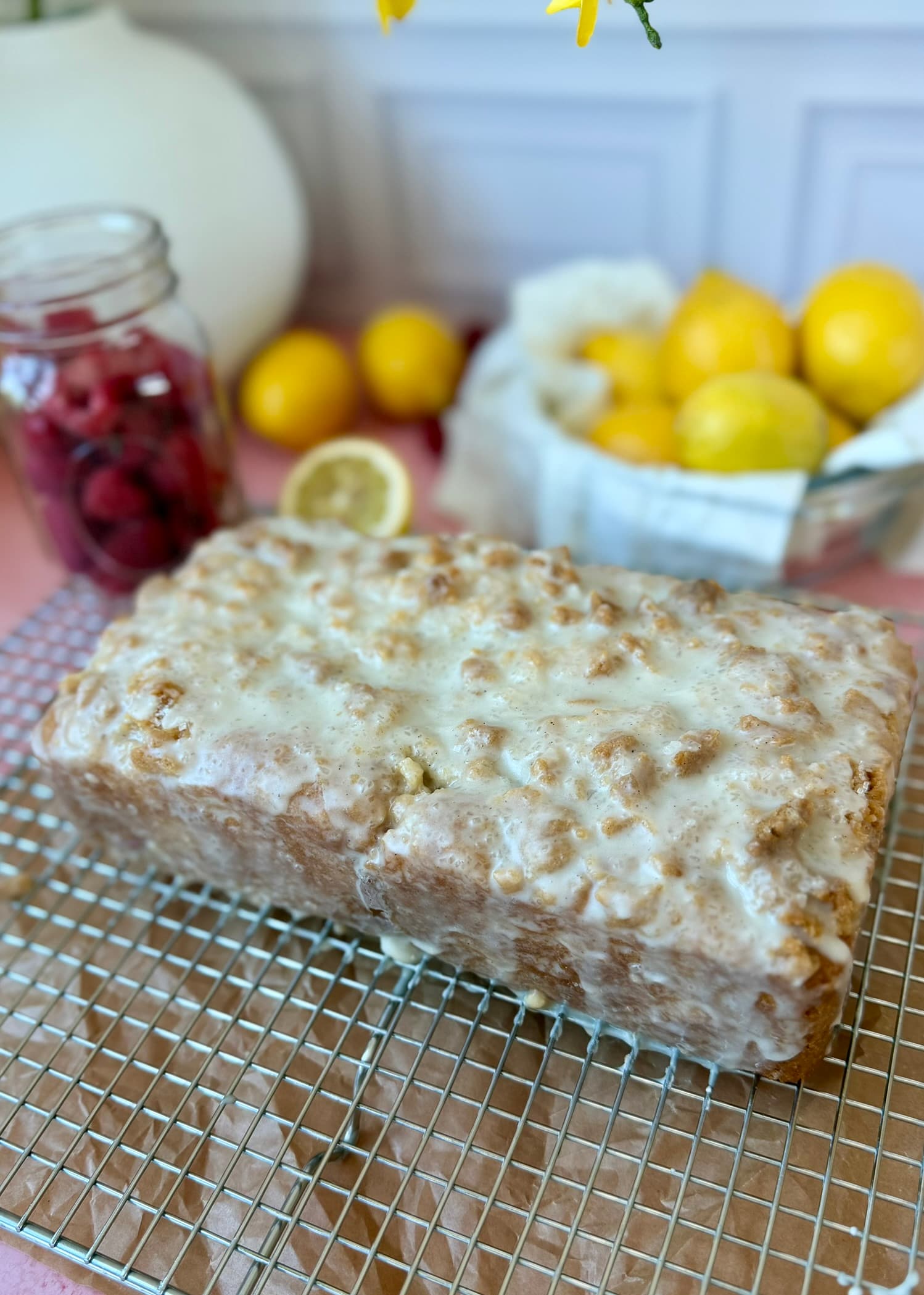 Whole glazed Lemon Raspberry Old-Fashioned Donut Loaf on a cooling rack