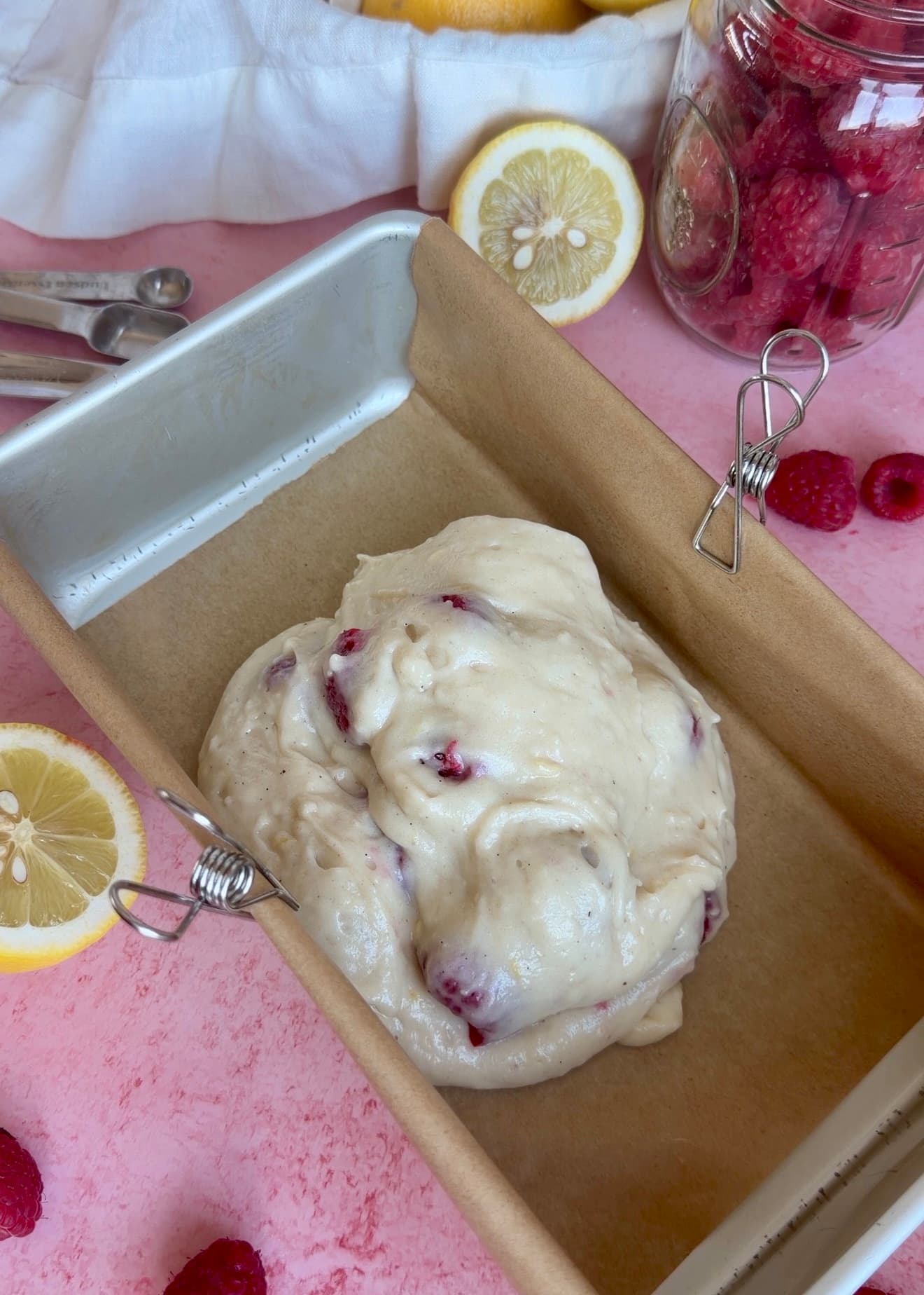 First layer of lemon raspberry batter in a lined loaf pan