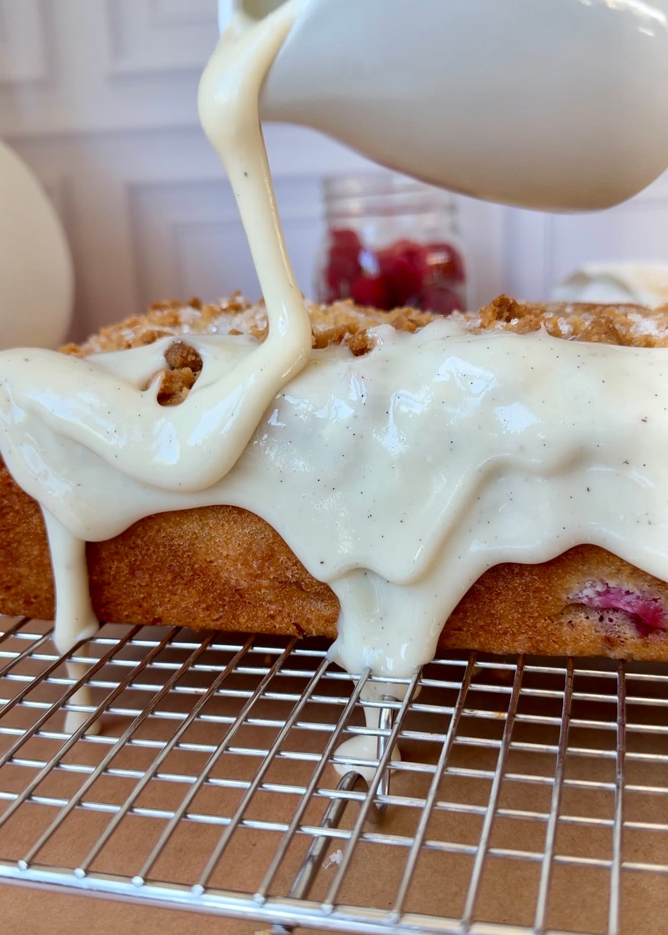Vanilla crackle glaze being poured over Lemon Raspberry Donut Loaf