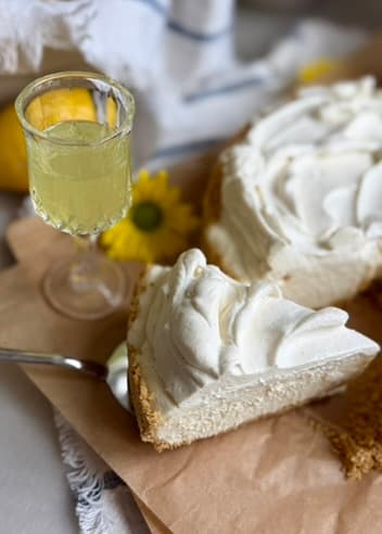 Slice of Limoncello Cheesecake Mousse beside a small glass of limoncello