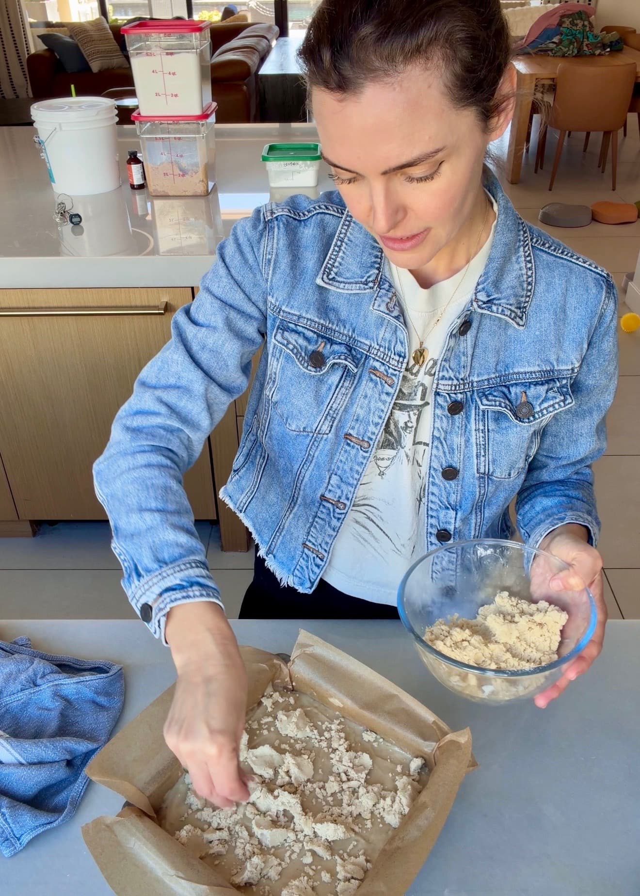 Angela scattering large crumble clusters over the cake batter