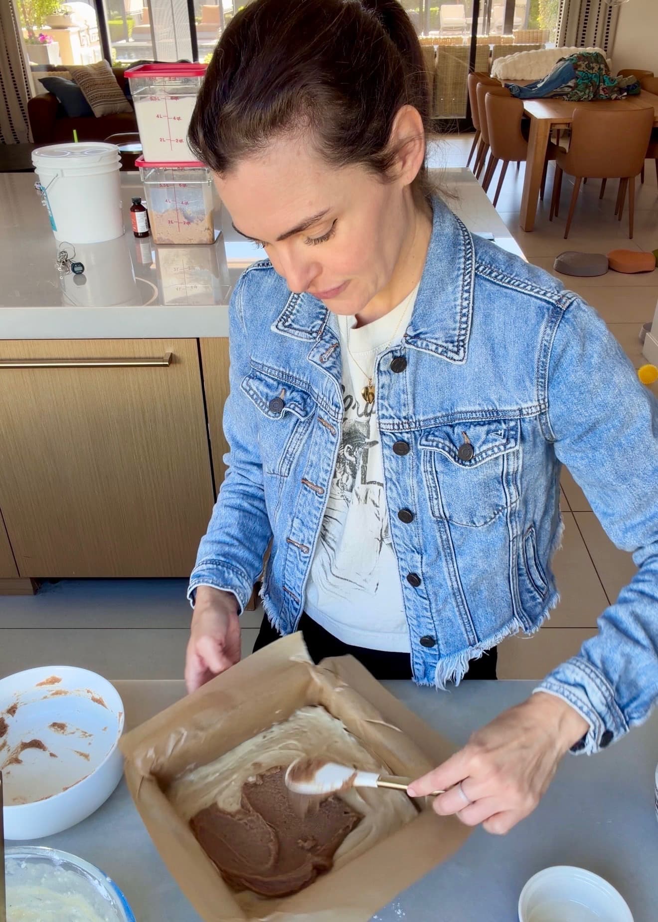 A spatula spreading cinnamon paste across the first layer of cake batter