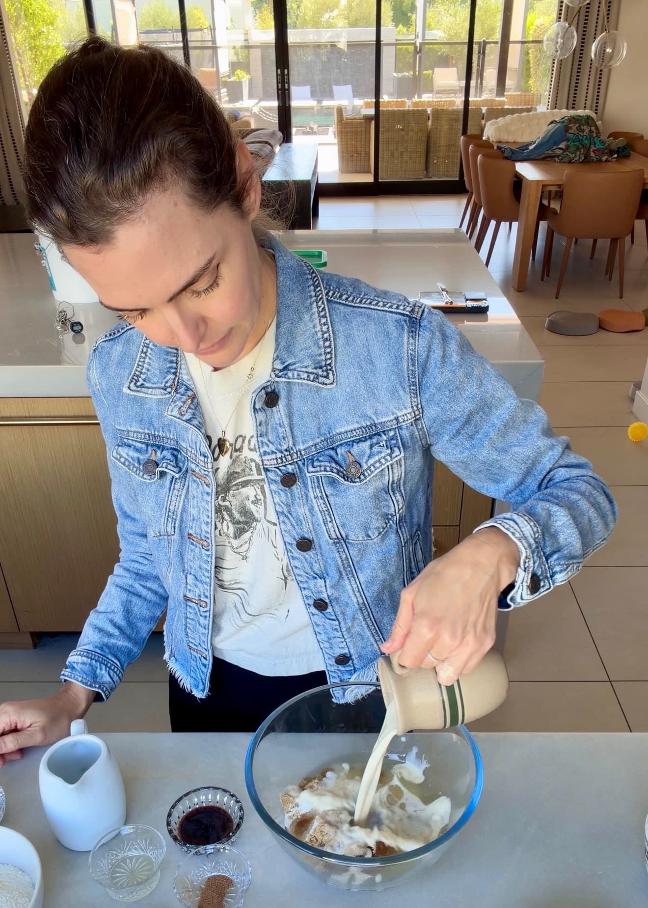 Milk pouring from a striped jug into the cake mixing bowl