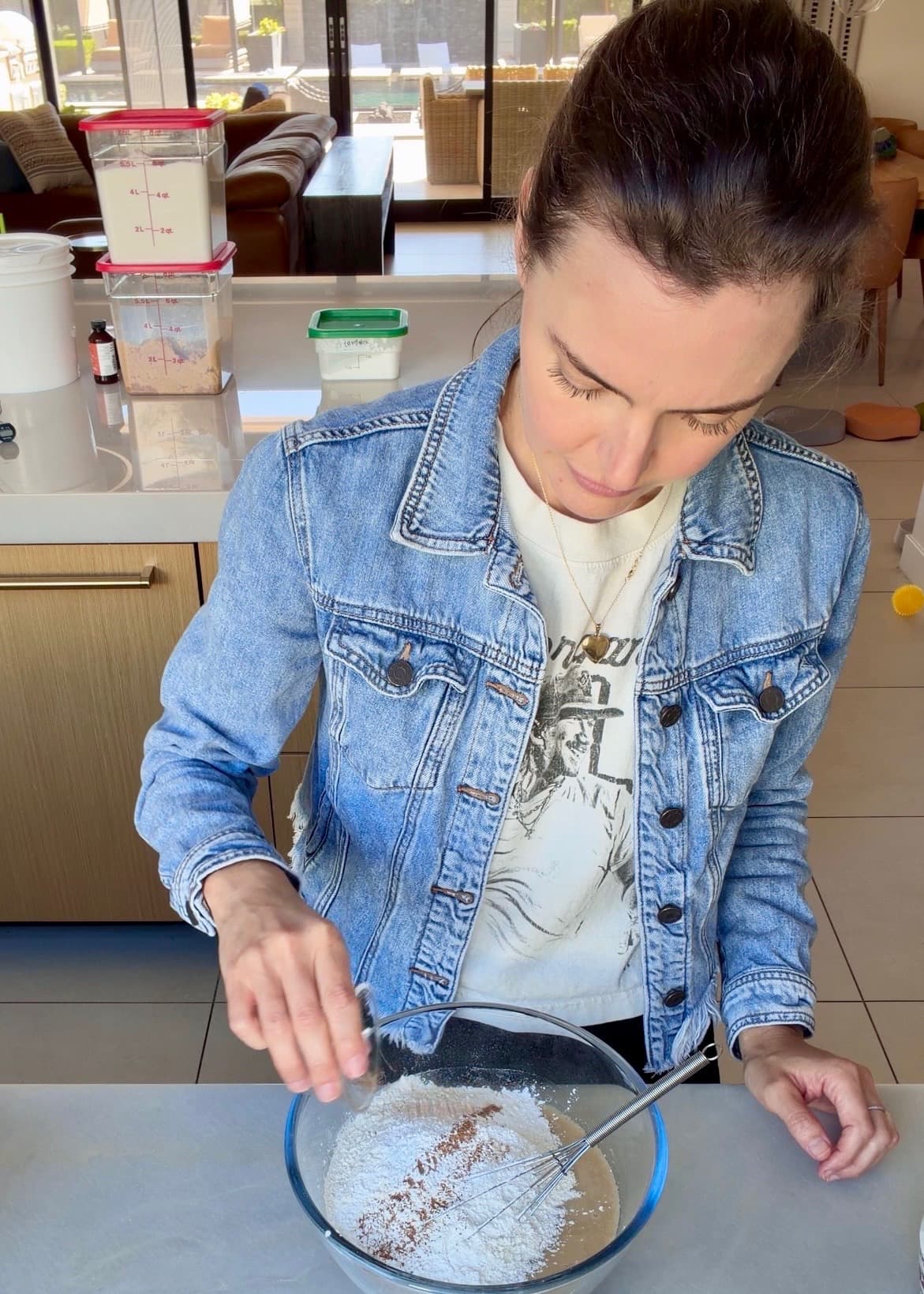 Ground spice being added over the flour in the mixing bowl