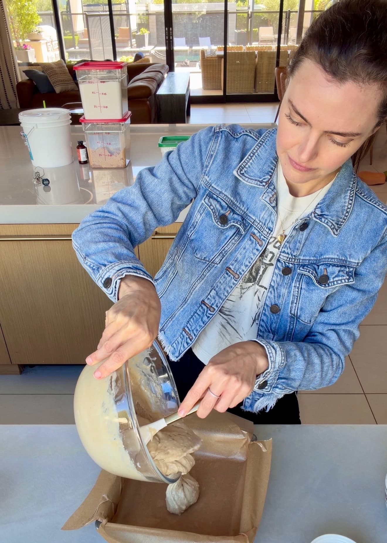 Maple cake batter being scraped into the parchment-lined pan