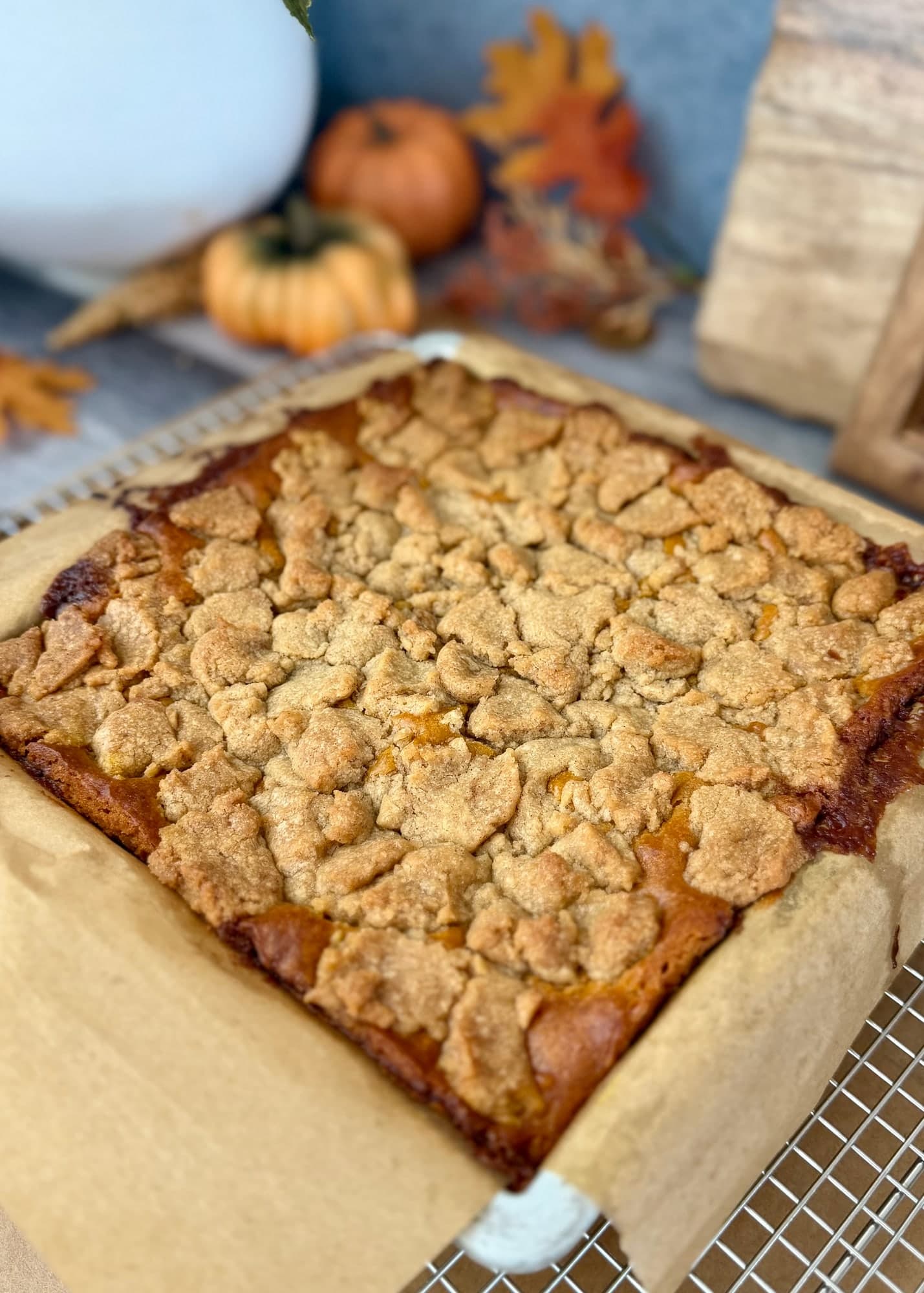 Baked cake with golden crumble and deep brown edges surrounded by parchment
