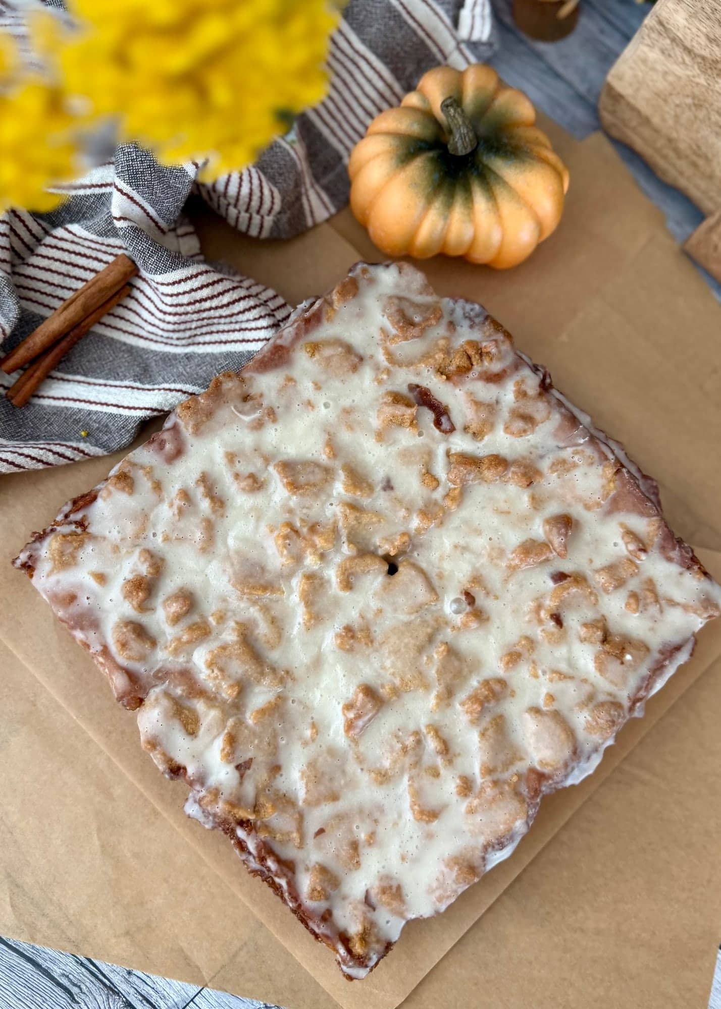 An overhead view of the whole pumpkin coffee cake with vanilla glaze over its crumble